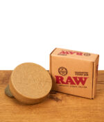 RAW Magnetic Stash Jar Hanfkunststoff-Dose geschlossen neben der Originalverpackung auf Holz.