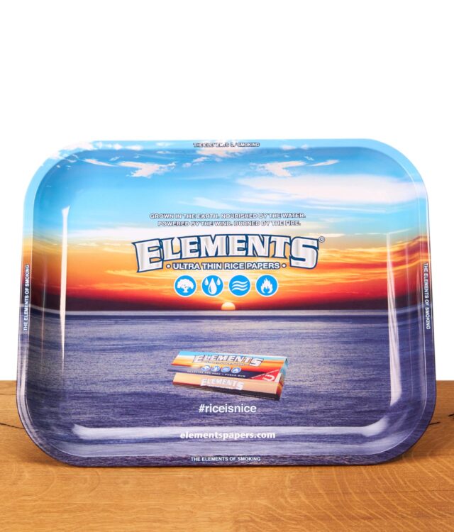 Rechteckiges Elements Rolling Tray aus Metall auf einem Holztisch. Die Drehunterlage zeigt ein Ozean-Sonnenuntergang-Motiv mit Markenlogo.