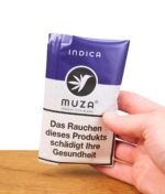 MUZA Tabakersatz Indica in violetter Packung wird in der Hand gehalten