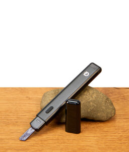 G Pen Melt Hot Knife ohne Kappe auf einem Stein platziert, elektronisches Dabbing-Werkzeug mit Bedienknopf und Keramik-Ladetipp.