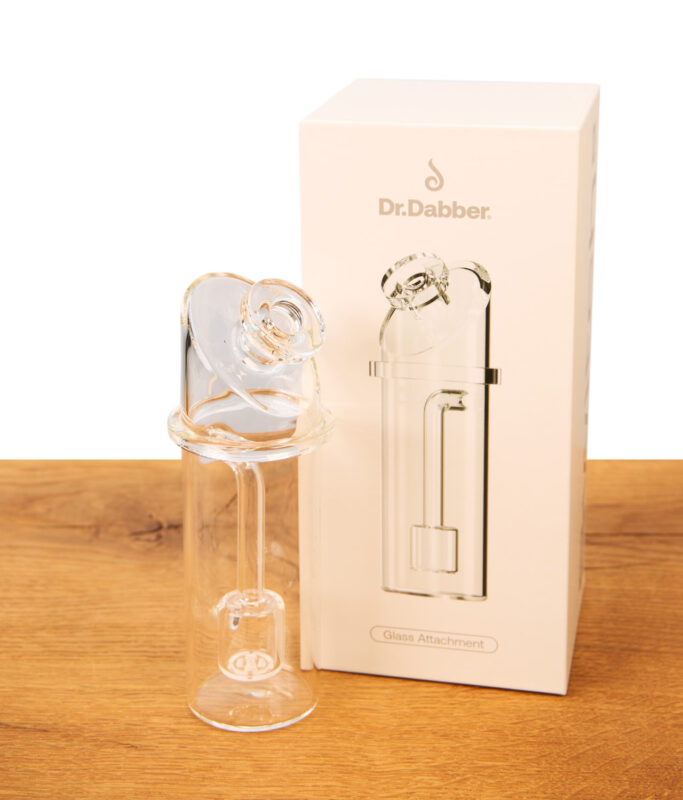 Dr. Dabber Switch 2 Ersatzglas aus Borosilikatglas neben seiner weißen Verpackung auf einer Holzoberfläche.
