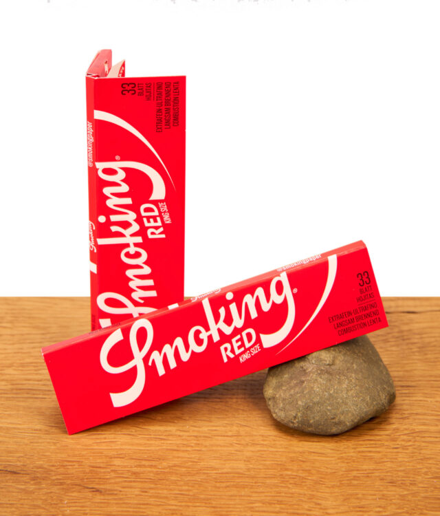Zwei rote Packungen Smoking Red King Size Blättchen auf einer Holzoberfläche
