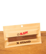 RAW X-Stand Drehhilfe in der originalen Papierverpackung aus nachhaltigem Bamboo-Plastic auf einem Holztisch.