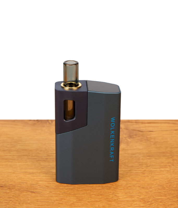 Wolkenkraft Äris Ultra Nightblue Vaporizer auf Holztisch. Blaues Aluminiumgehäuse, magnetische Kappe und Borosilikatglas-Mundstück.