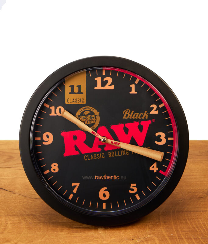 Frontansicht der RAW Black Stash Clock auf Holz. Funktionierende Versteckuhr im RAW-Design mit auffälligen, konischen Joint-Zeigern.