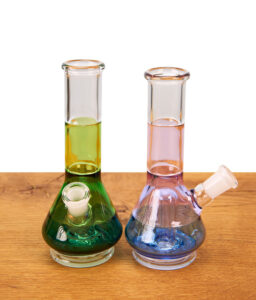 Zwei BigFun Tricolor Peak Top Glasaufsätze aus Borosilikatglas in Grün und Blau auf Holztisch.