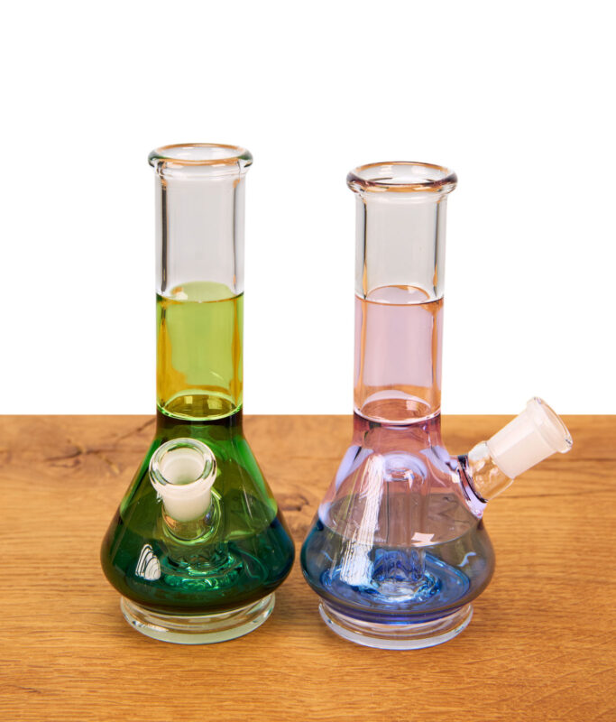 Zwei BigFun Tricolor Peak Top Glasaufsätze aus Borosilikatglas in Grün und Blau auf Holztisch.