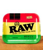 RAW Rolling Tray Rasta Large aus Metall auf Holz. Glatte Drehunterlage mit RAW-Logo im klassischen Rot-Gelb-Grün-Design.