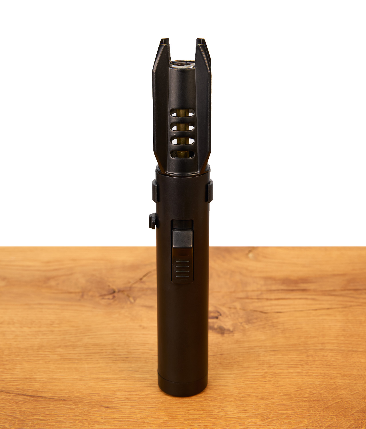 tobaliq-jetflame-brenner-jpg Schwarzer Tobaliq Jetflame Brenner im Raketen-Design auf Holztisch mit Piezo-Zündung und Belüftungsschlitzen.