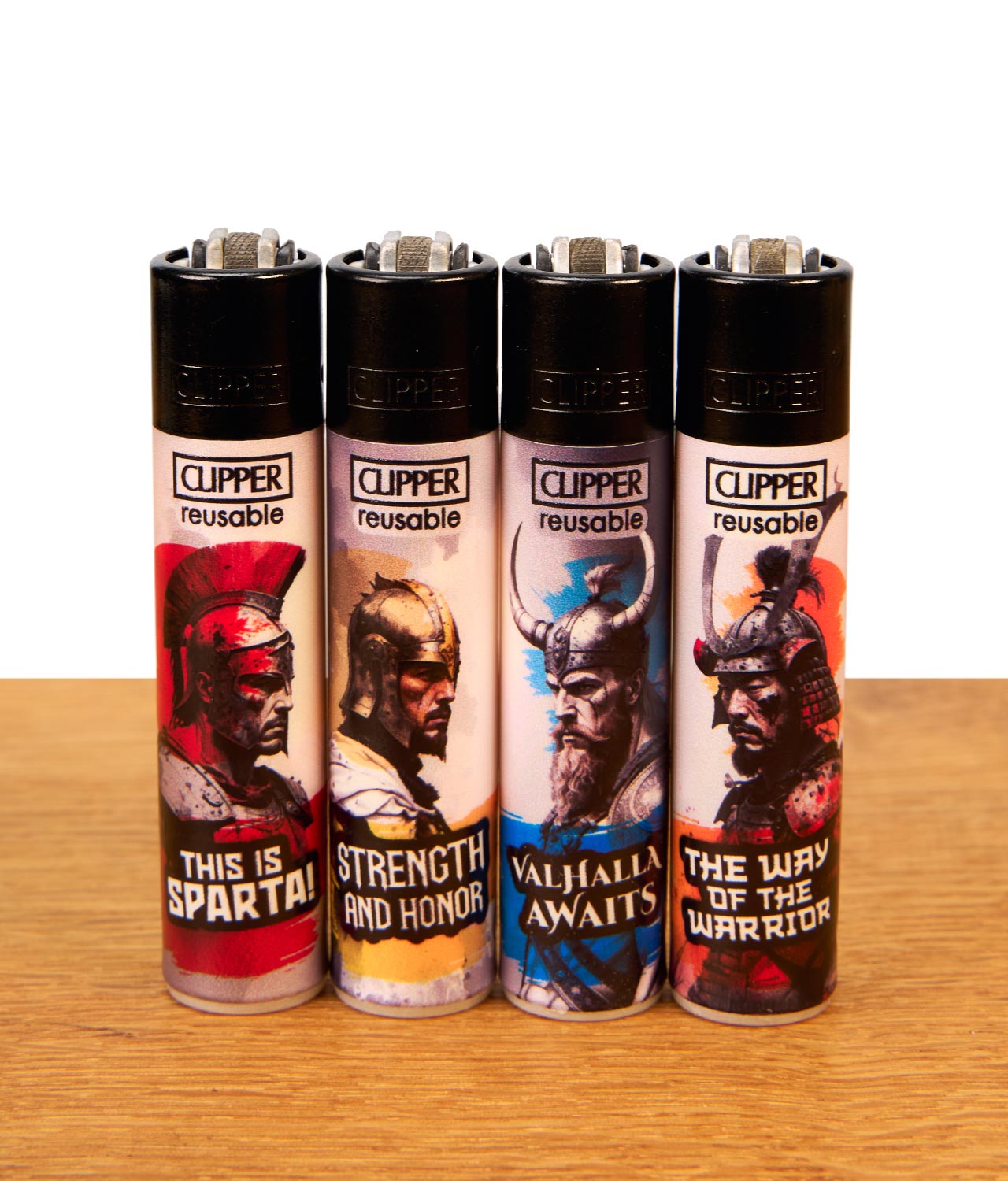 clipper-ffx-warriors-4er-serie-jpg Wiederbefüllbares Clipper Feuerzeug 4er-Set FFX Warriors mit Krieger-Motiven auf Holzoberfläche.