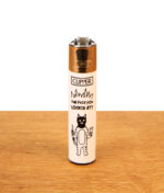 Nachfüllbares Clipper Feuerzeug FFX Trouble Catz mit Motiv „The Fuck You Lookin At?“ und Metallkopf auf Holz.