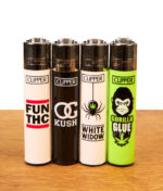 : Vier nachfüllbare Clipper Metallkopf-Feuerzeuge der 420 Slogan-Serie auf Holzgrund: Motive FUN THC, OG Kush, White Widow, Gorilla Glue.