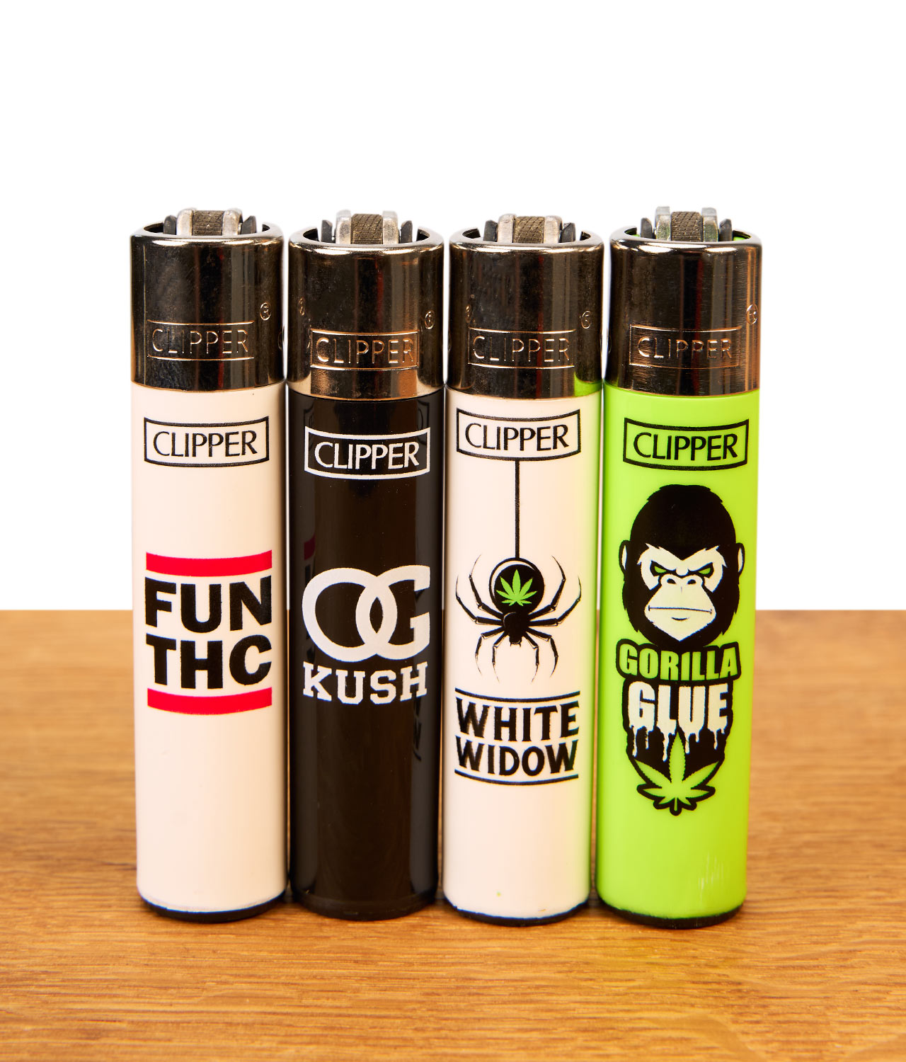 clipper-ffx-420-slogan-1-jpg : Vier nachfüllbare Clipper Metallkopf-Feuerzeuge der 420 Slogan-Serie auf Holzgrund: Motive FUN THC, OG Kush, White Widow, Gorilla Glue.