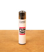 Weißes Clipper Feuerzeug 420 Slogan FUN THC mit rot-schwarzem Motivdruck auf einer Holzoberfläche.