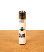 Clipper Feuerzeug 420 Slogan White Widow in Weiß mit Spinnen- und Hanfblatt-Motiv auf Holzgrund.
