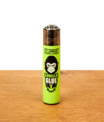 Neongrünes Clipper Feuerzeug 420 Slogan Gorilla Glue mit Gorilla-Illustration auf einer Holzplatte.